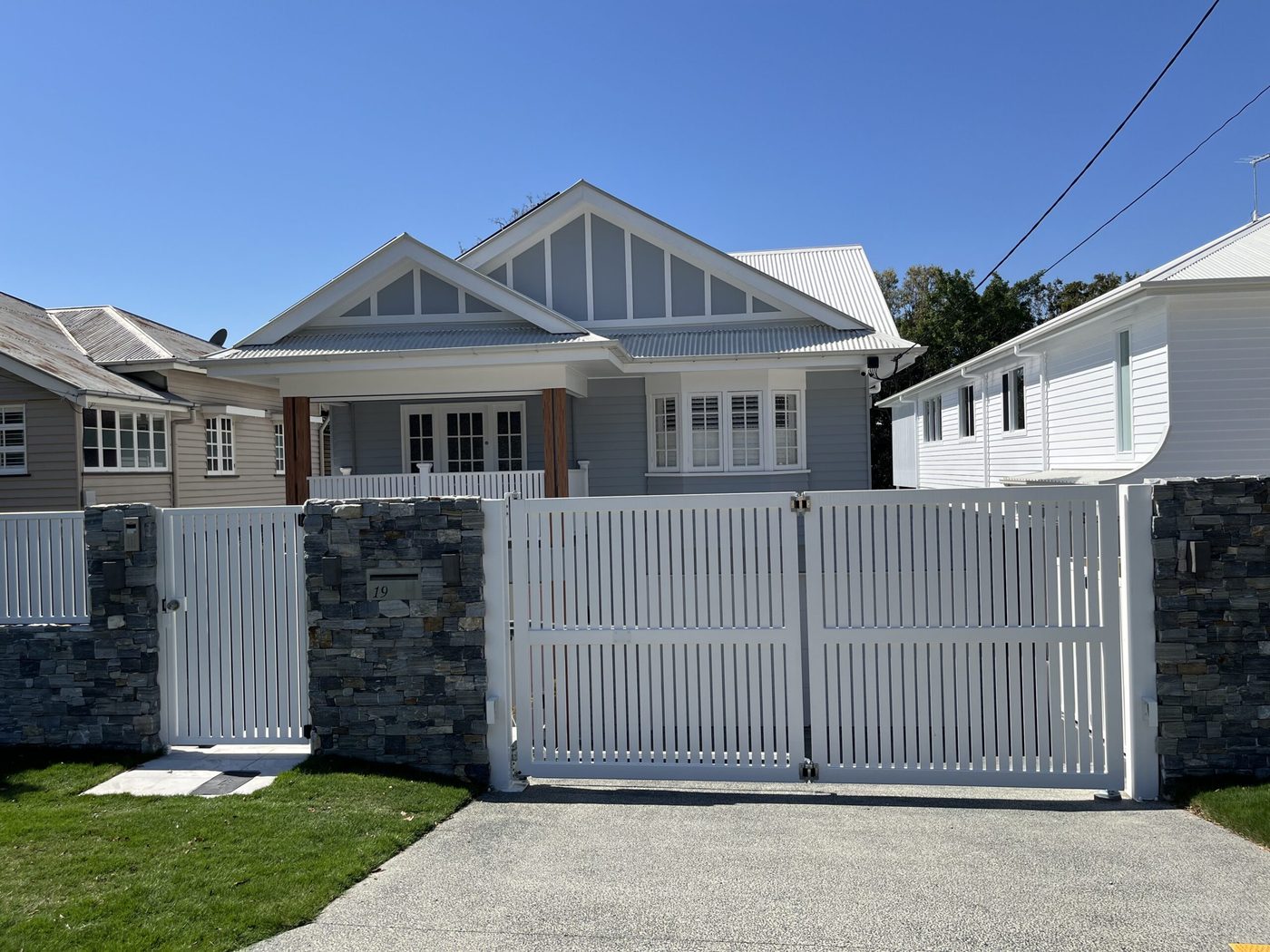 White vertical slat bi-fold gate and fence on a Queenslander